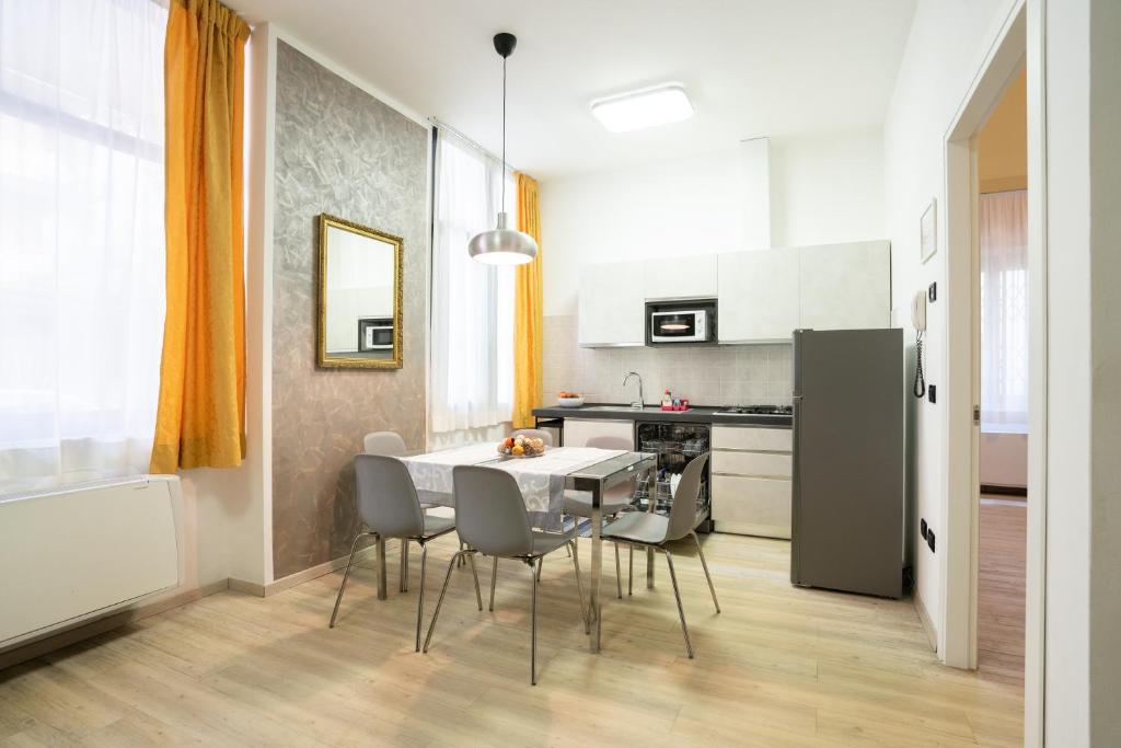 une cuisine avec une table et des chaises dans une pièce dans l'établissement Residence Millennium, à Rimini