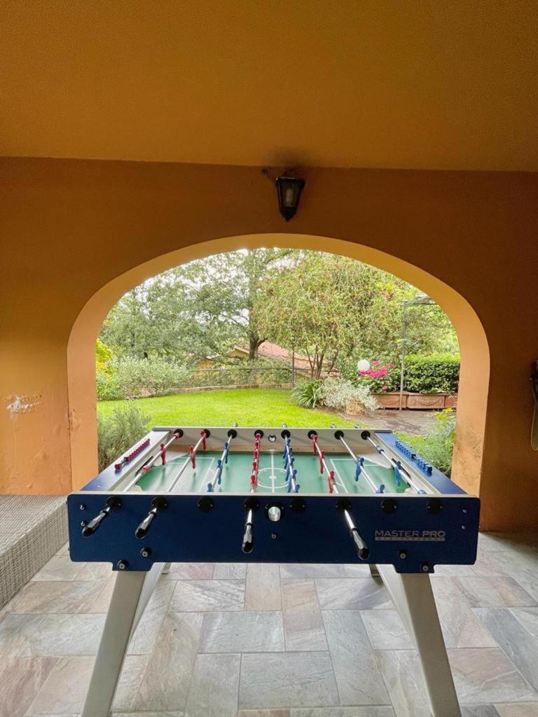 - une table de ping-pong dans une pièce avec arche dans l'établissement Deliziosa Villa alle porte di Roma, à Sacrofano