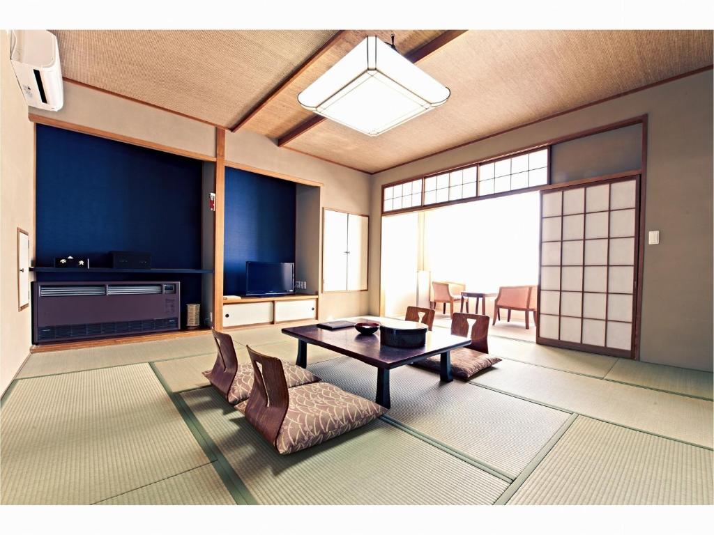 un salon avec une table et des chaises dans l'établissement 湯宿みゆきYuyado Miyuki, à Kusatsu