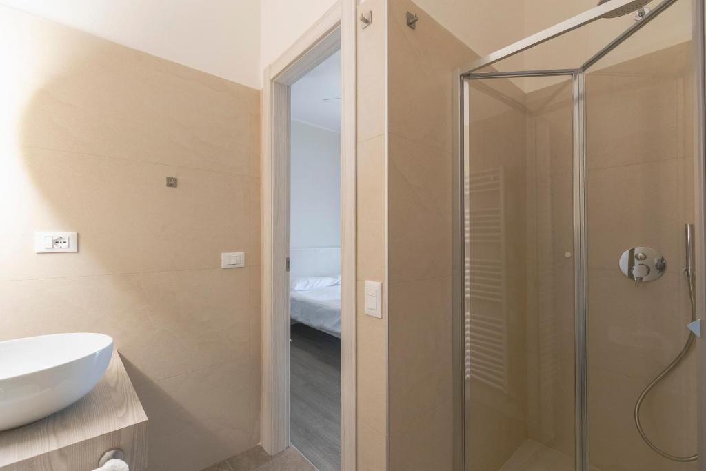 une salle de bain avec douche et lavabo dans l'établissement Hotel Nettuno, à Brenzone