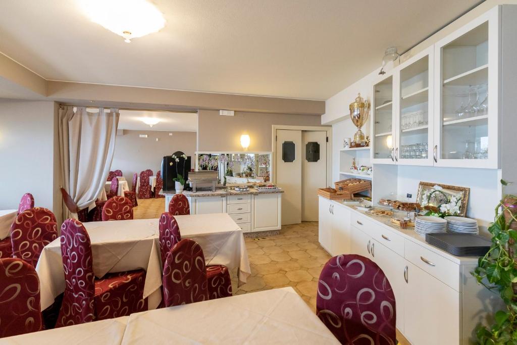 une cuisine et une salle à manger avec une table et des chaises dans l'établissement Hotel Nettuno, à Brenzone 86 autres photos