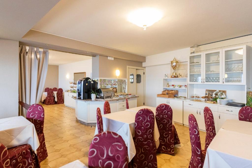 une chambre avec des chaises et une table ainsi qu'une cuisine dans l'établissement Hotel Nettuno, à Brenzone