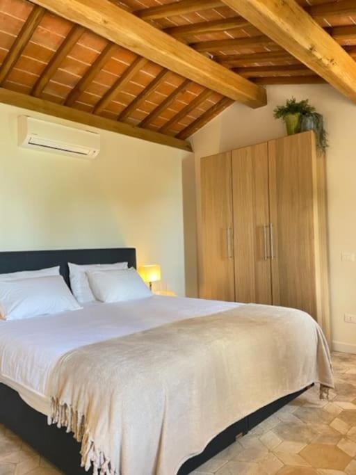 - une chambre avec un grand lit blanc et des plafonds en bois dans l'établissement Villa la Madonna with pool and padelcourt, à Monte del Lago 37 autres photos