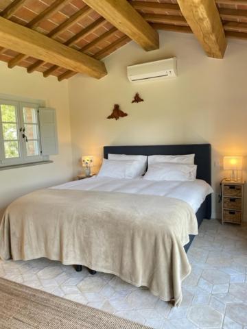 une chambre avec un grand lit avec des draps blancs dans l'établissement Villa la Madonna with pool and padelcourt, à Monte del Lago