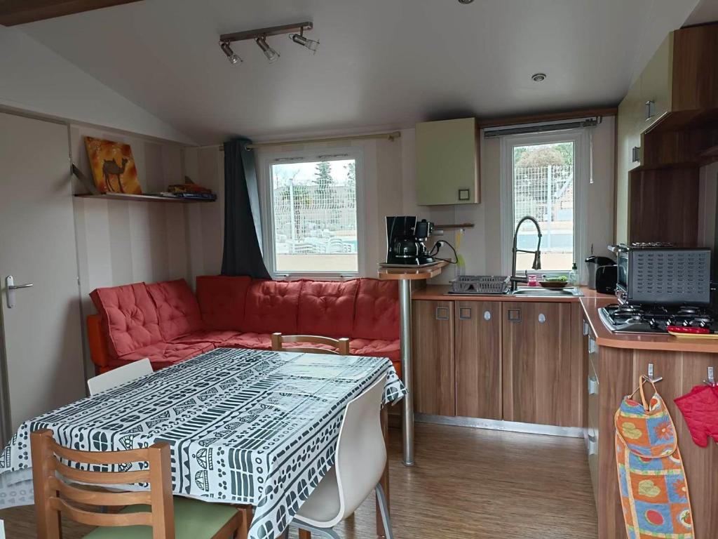 - une cuisine avec une table et un canapé dans une chambre dans l'établissement MOBIL HOME LMNP GUIGON, à La Roque-dʼAnthéron