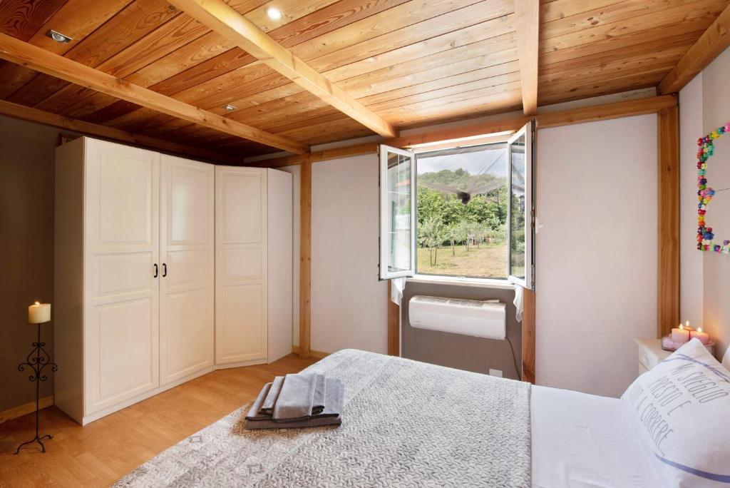 une chambre avec un grand lit et une fenêtre dans l'établissement Barcollo House - Piscina nel verde, à Stella