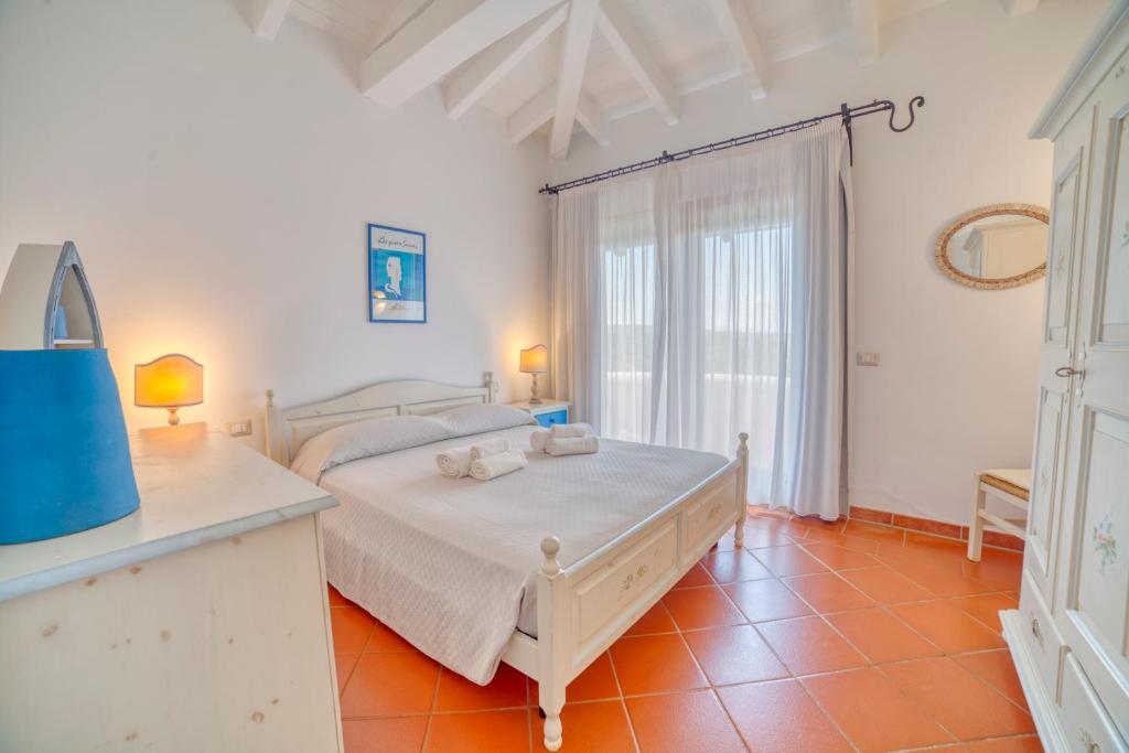 une chambre avec un lit et une grande fenêtre dans l'établissement Villa Hibiscus Stintino, à Stintino 27 autres photos