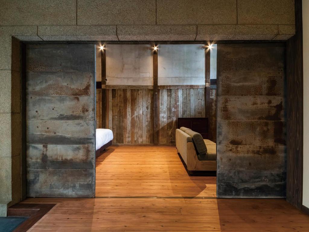 Cette chambre comprend un lit et une porte coulissante en verre. dans l'établissement NIPPONIA Chichibu Monzenmachi, à Chichibu
