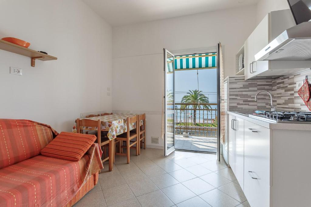 un salon avec un canapé et une cuisine avec une table dans l'établissement Residence Villa Alda, à Pietra Ligure