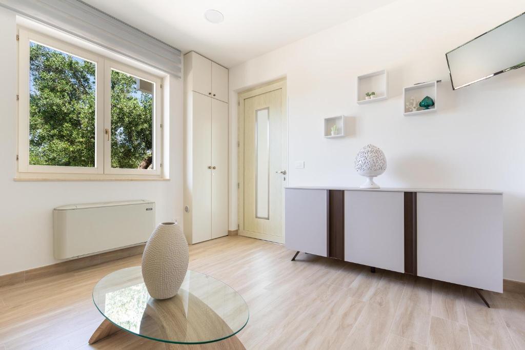 - un salon avec une table en verre et une fenêtre dans l'établissement Villa Eva by Perle di Puglia, à San Michele Salentino