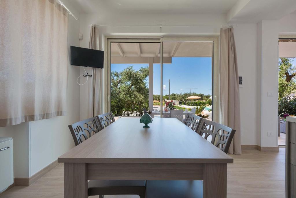 une table à manger avec un vase au-dessus dans l'établissement Villa Eva by Perle di Puglia, à San Michele Salentino