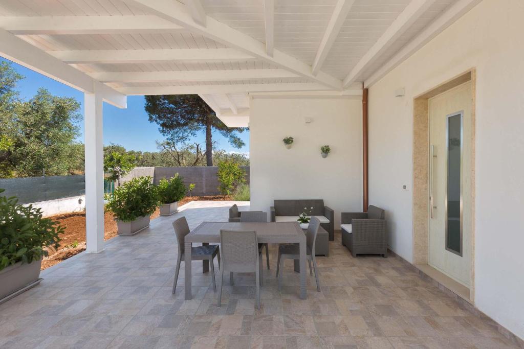 un patio avec une table et des chaises dessus dans l'établissement Villa Eva by Perle di Puglia, à San Michele Salentino