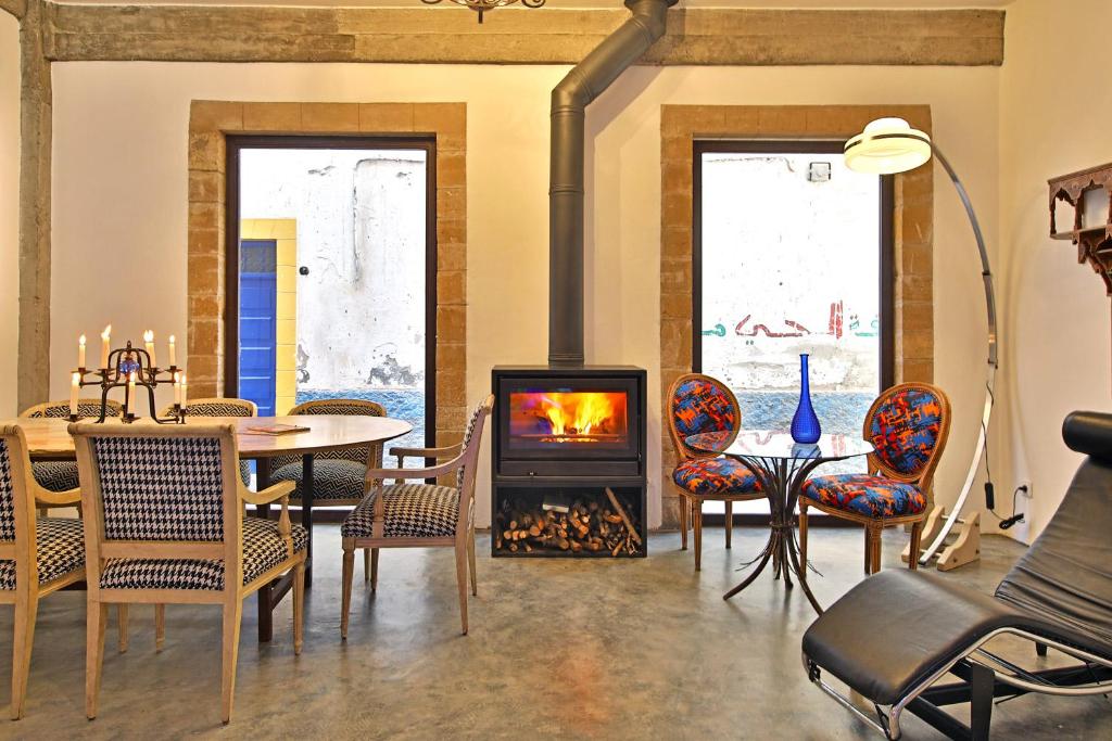 - un salon avec une cheminée, une table et des chaises dans l'établissement Riad EspritBleu - Adult Only, à Essaouira