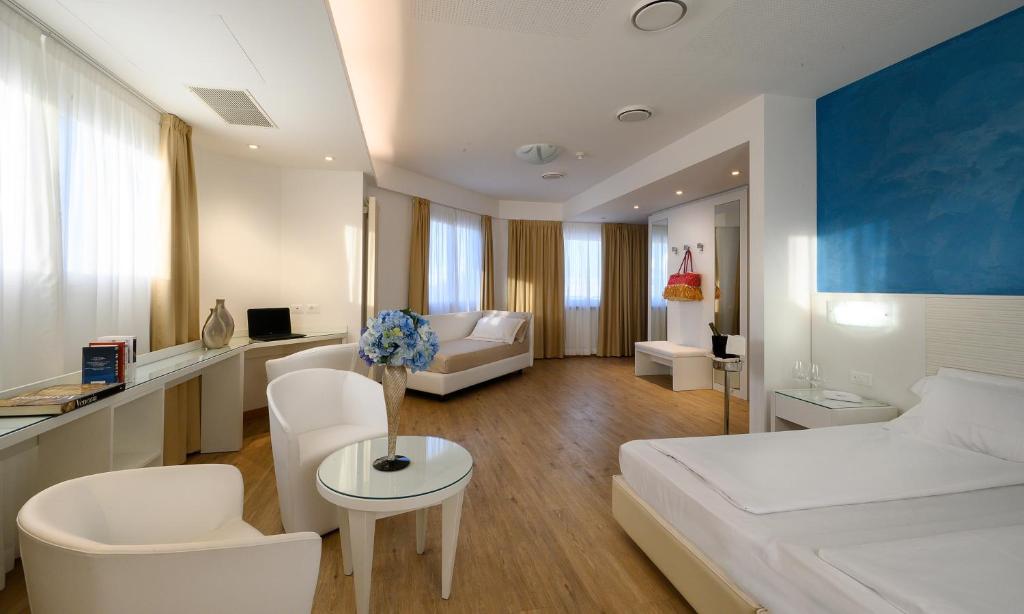 une chambre avec un lit et un salon dans l'établissement Grand Hotel Playa, à Lignano Sabbiadoro 133 autres photos