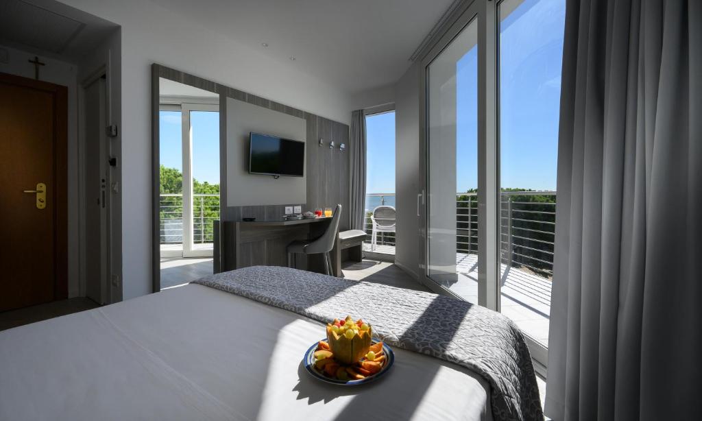 une chambre avec un lit avec vue sur un balcon dans l'établissement Grand Hotel Playa, à Lignano Sabbiadoro