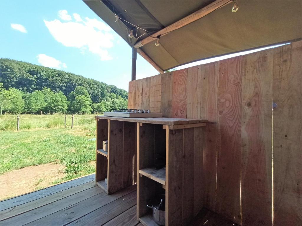 un bâtiment en bois avec un comptoir sur une terrasse dans l'établissement Le Lodge du Hibou, à Quarré-les-Tombes