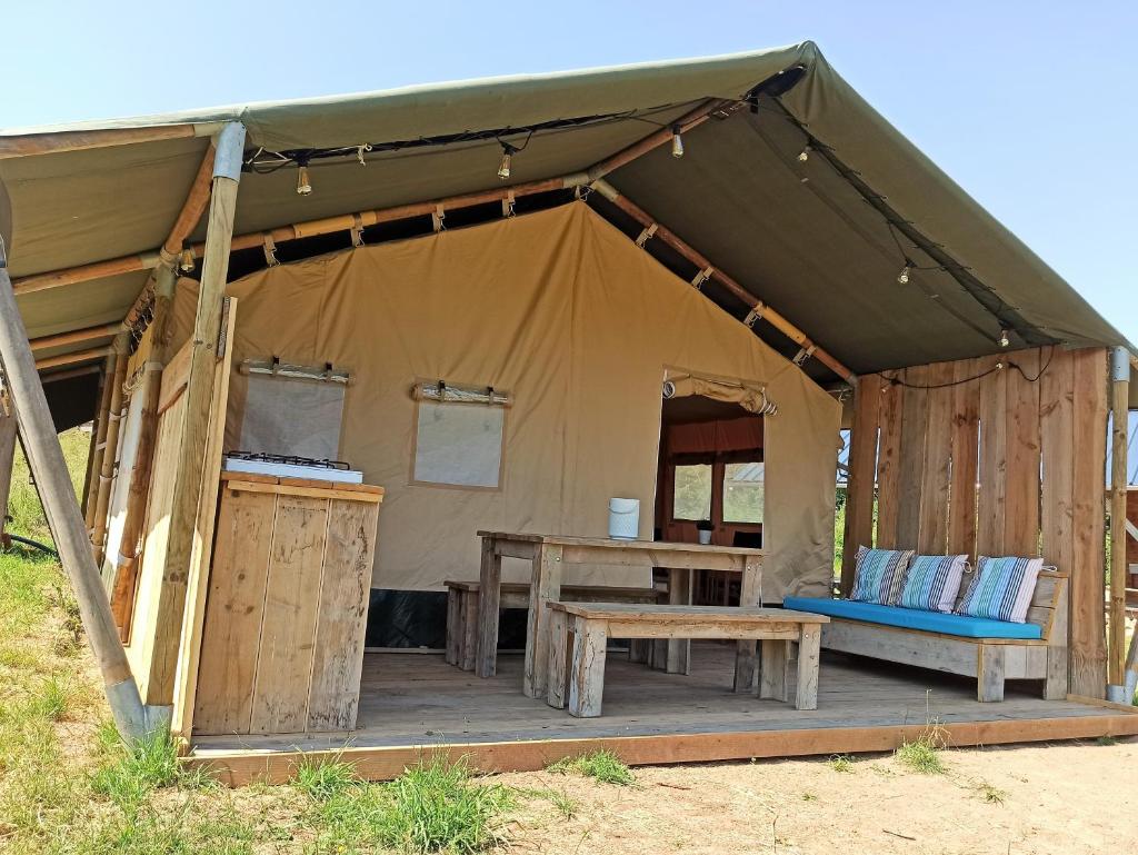 une tente avec une table en bois et un banc dans l'établissement Le Lodge du Hibou, à Quarré-les-Tombes