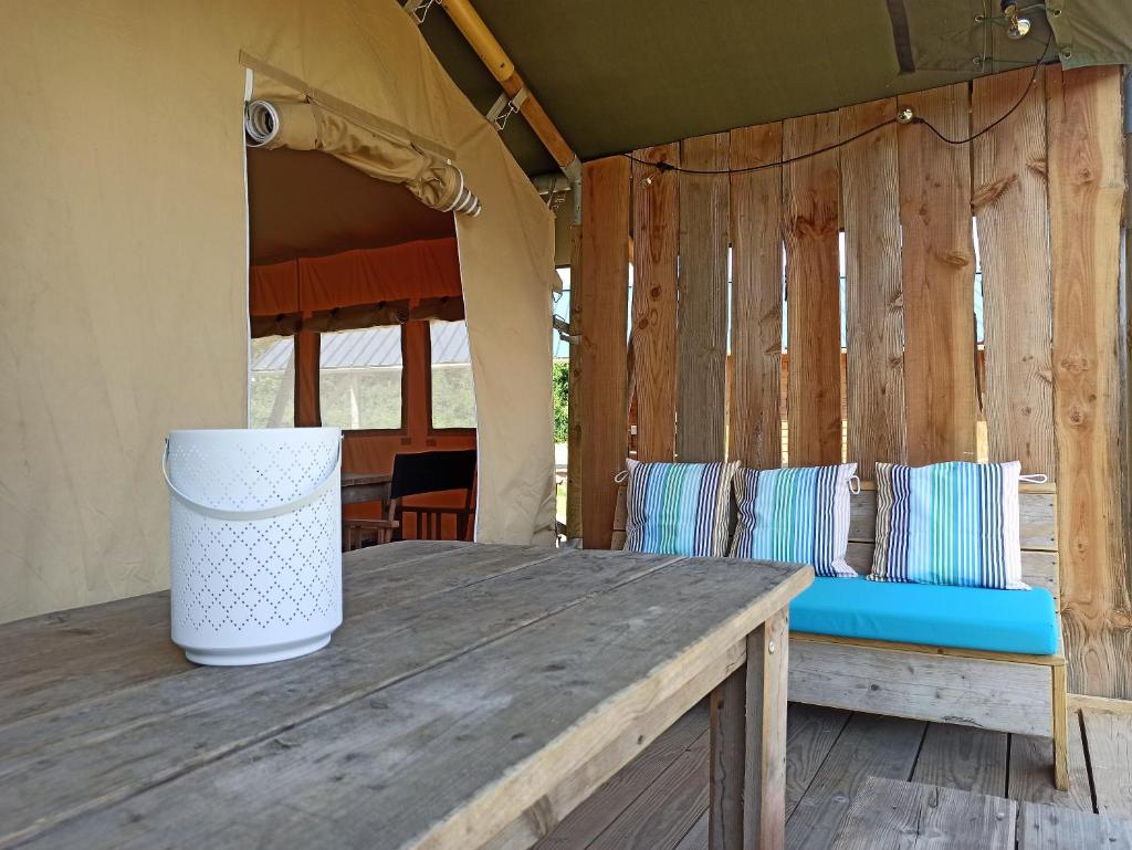 une table en bois avec un banc et une tente dans l'établissement Le Lodge du Hibou, à Quarré-les-Tombes