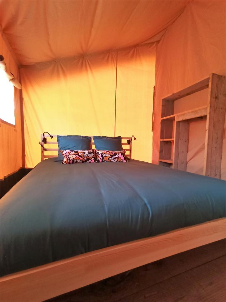 - un lit dans une tente avec 2 oreillers dans l'établissement Le Lodge du Hibou, à Quarré-les-Tombes