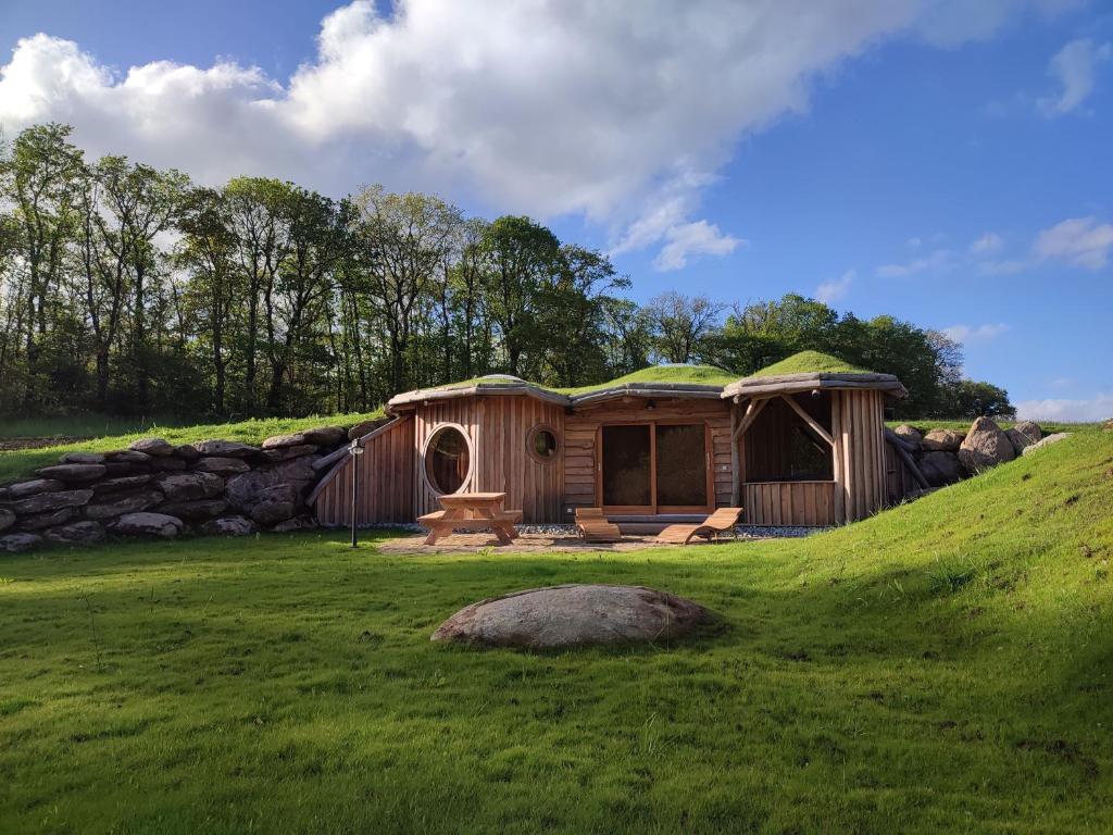 une cabane en bois avec un toit en herbe sur une colline dans l'établissement La Cabane Korrigans, à Gommené