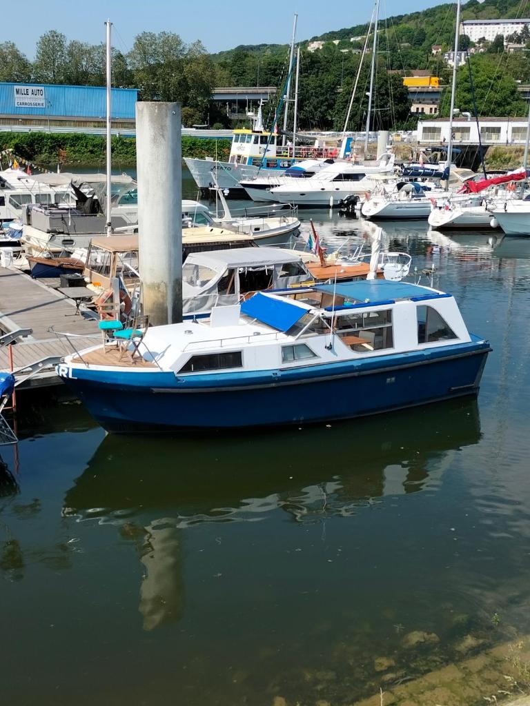 un bateau bleu et blanc amarré dans un port dans l'établissement Bateau PEARL, à Rouen