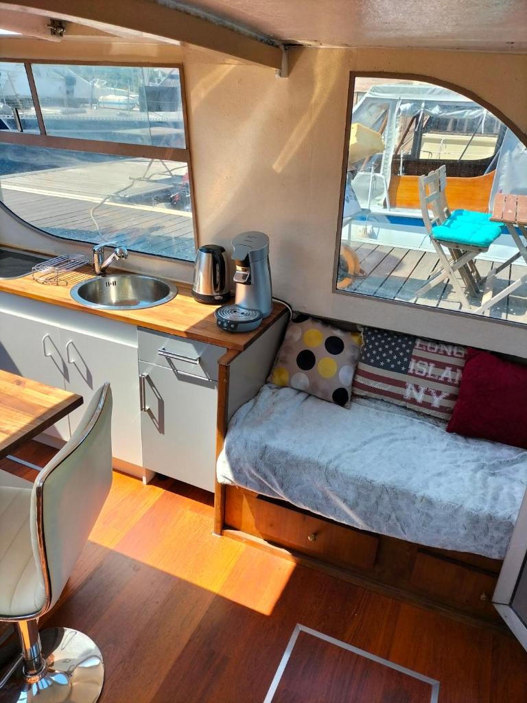une chambre avec un lit et un lavabo dans un bateau dans l'établissement Bateau PEARL, à Rouen
