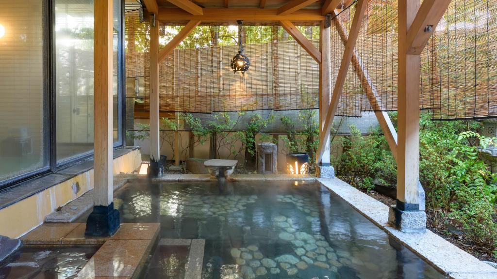 une piscine d'eau dans un bâtiment avec un toit dans l'établissement Tamaya Ryokan, à Ueda