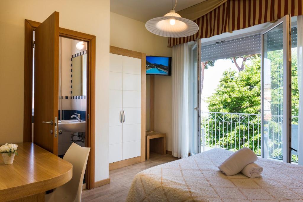 une chambre avec un lit, un bureau et une fenêtre dans l'établissement Hotel Sylvia, à Lido di Camaiore
