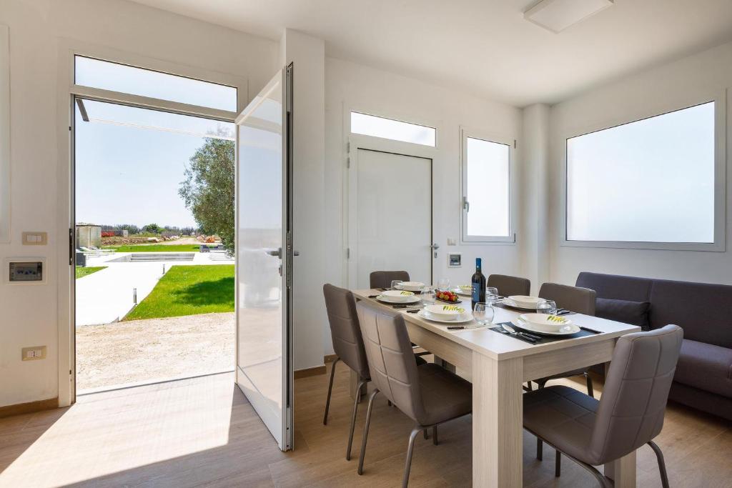 une salle à manger avec une table et des chaises blanches dans l'établissement Villa La Quiete by BarbarHouse, à Copertino
