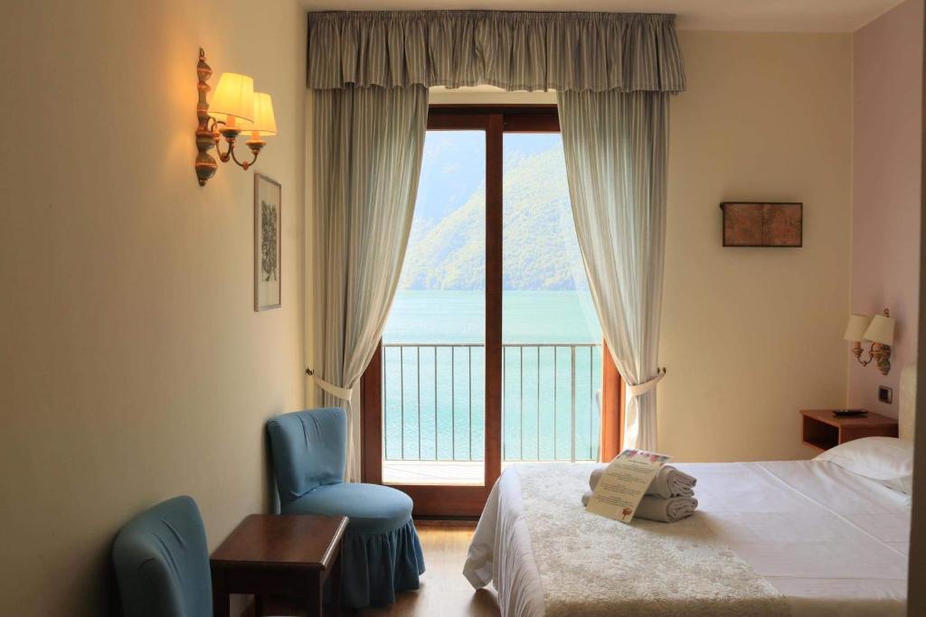 une chambre d'hôtel avec un lit et une fenêtre avec vue dans l'établissement Hotel Stella D'Italia, à Valsolda