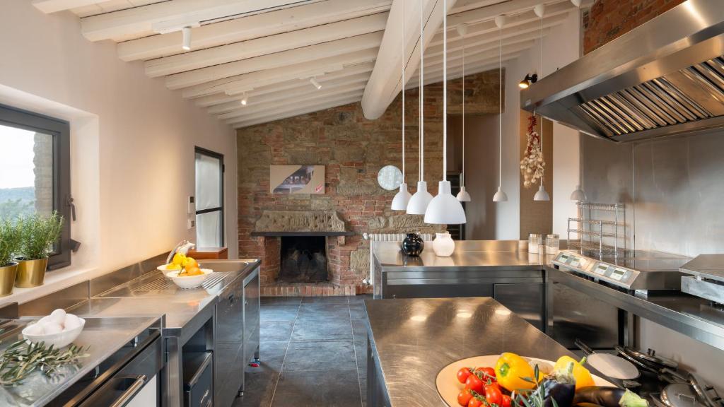 une grande cuisine avec une cheminée au milieu dans l'établissement AQUADIVINA 16, Emma Villas, à Palaia