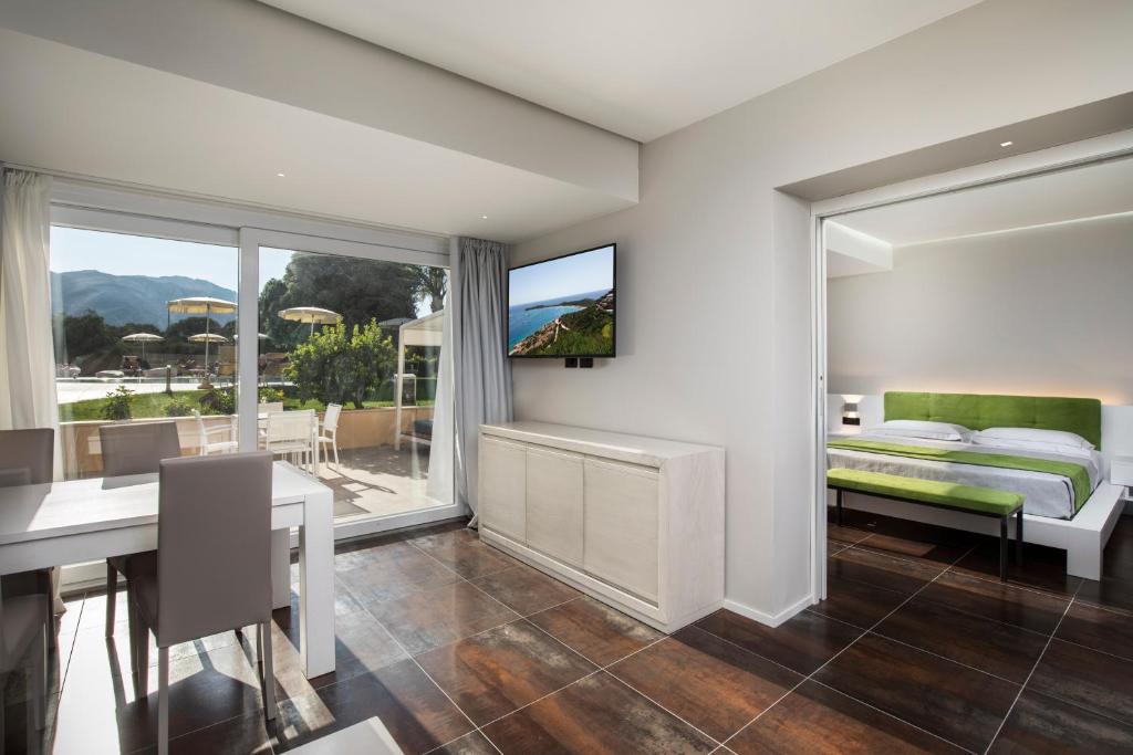 une chambre avec un lit et une salle à manger avec une table dans l'établissement Hotel San Teodoro, à San Teodoro