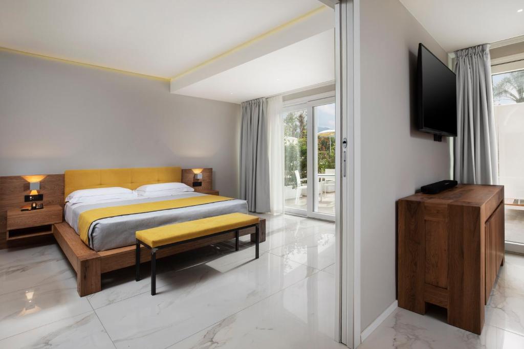 une chambre avec un lit et une porte coulissante en verre dans l'établissement Hotel San Teodoro, à San Teodoro