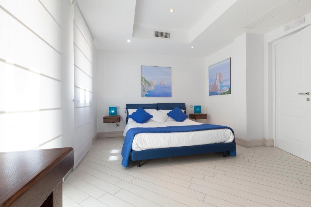une chambre avec un lit bleu dans une pièce blanche dans l'établissement Villa Eva, à Sorrente 69 autres photos