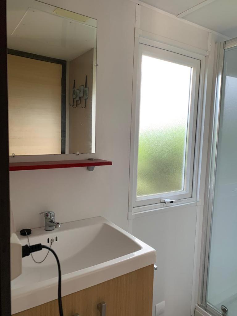 une salle de bain avec un lavabo, un miroir et une fenêtre dans l'établissement Mobilhome dans résidence, à Ruoms