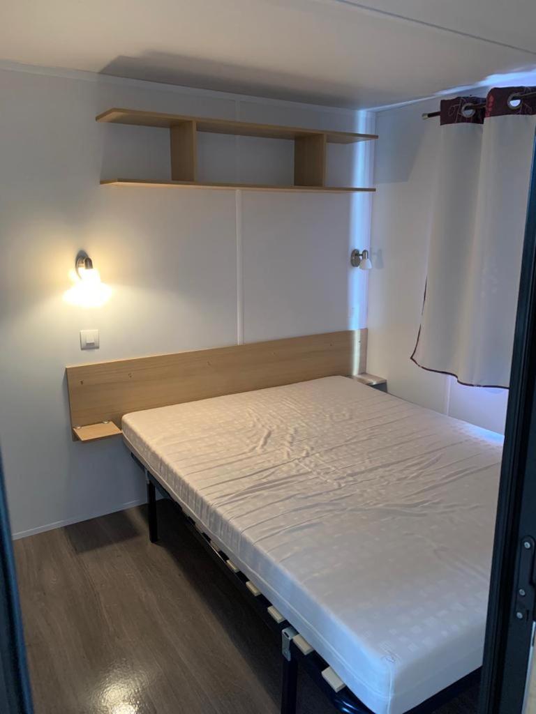 Cette petite chambre comprend un lit et une lampe. dans l'établissement Mobilhome dans résidence, à Ruoms