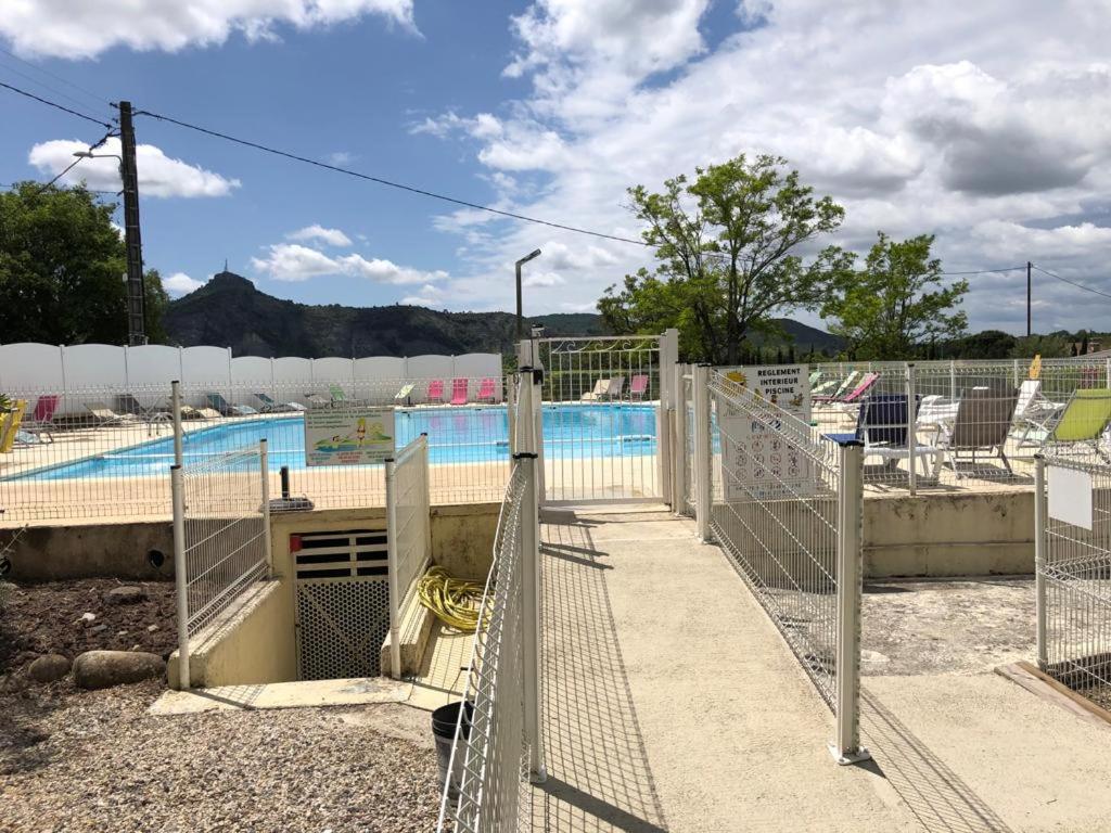 une piscine entourée d'une clôture dans l'établissement Mobilhome dans résidence, à Ruoms