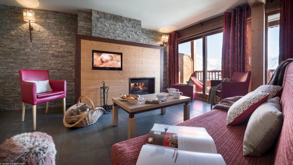 un salon avec un canapé et une cheminée dans l'établissement Résidences Village Montana by Les Etincelles, à Tignes 37 autres photos