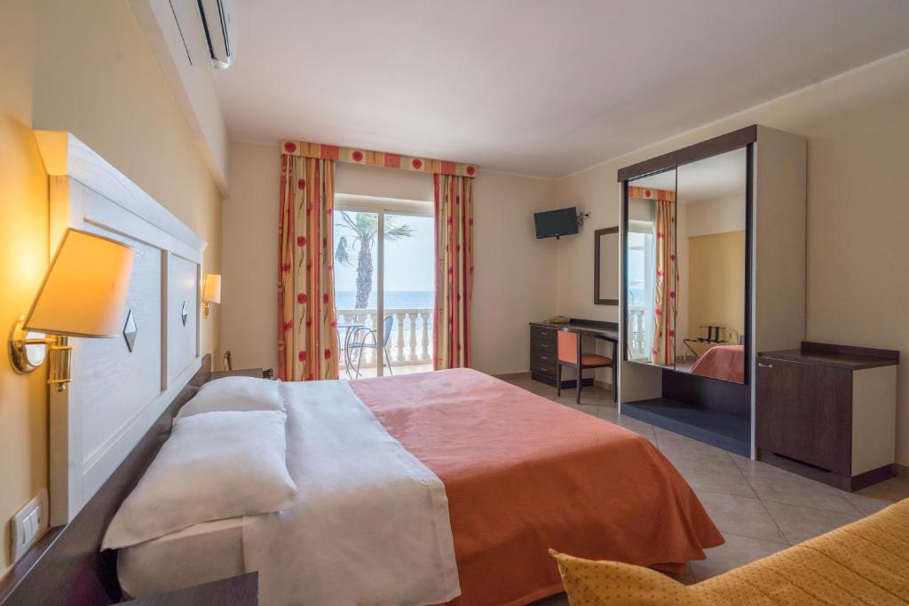 une chambre d'hôtel avec un grand lit et un balcon dans l'établissement Hotel Orizzonte, à Letojanni 38 autres photos