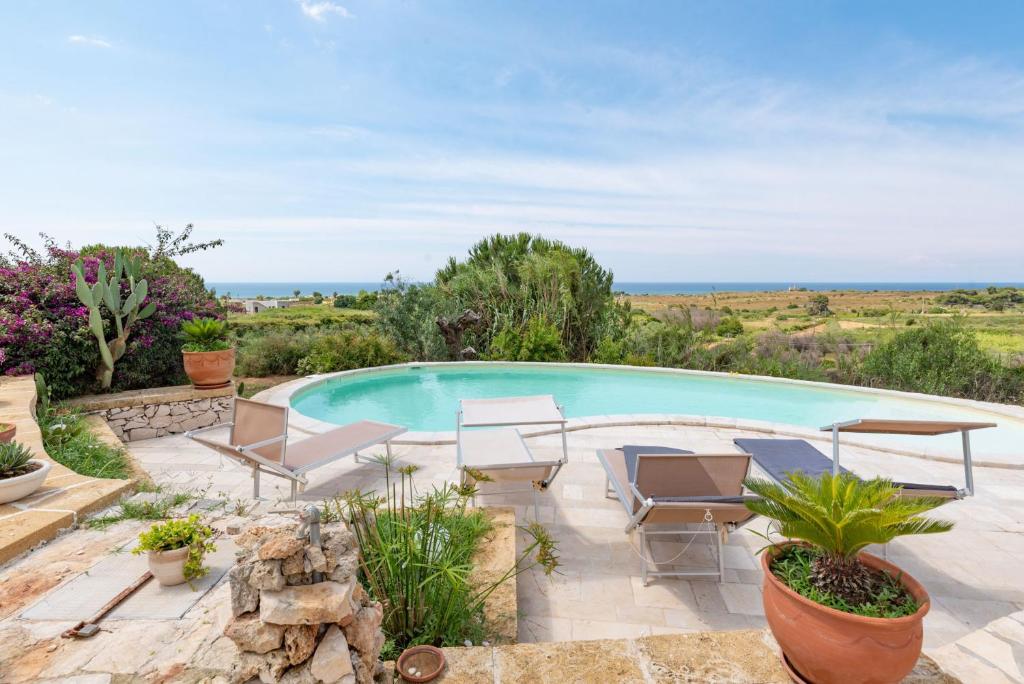 - une piscine dans une cour avec mobilier de jardin dans l'établissement VILLA Alessandra, à Marina di Pescoluse