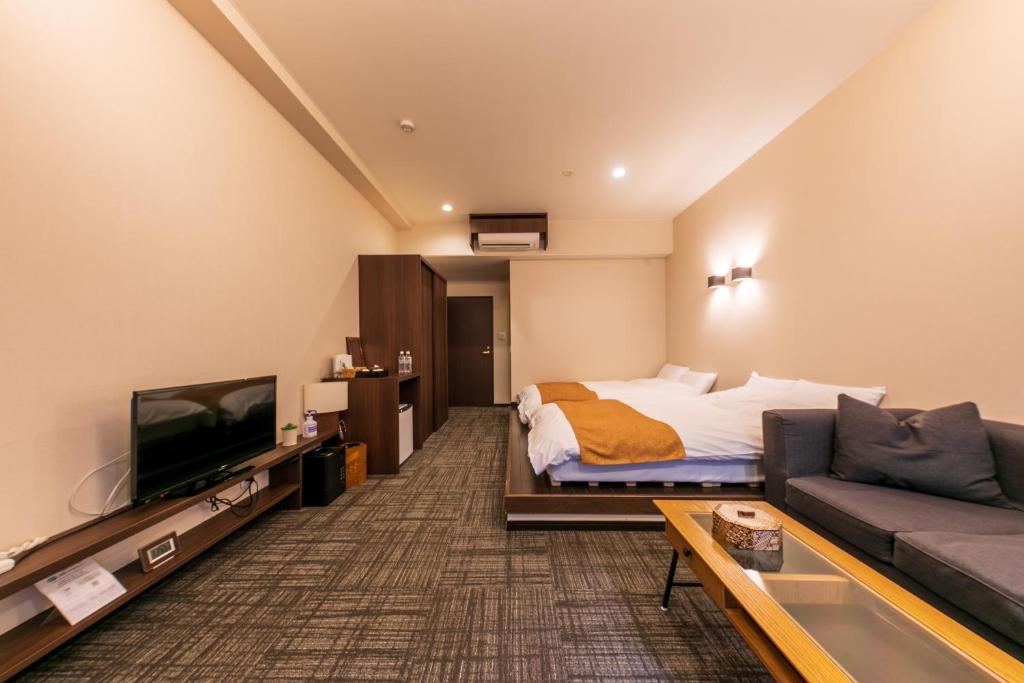 une chambre d'hôtel avec un lit et un canapé dans l'établissement Sengokuhara Hisanoha, à Hakone