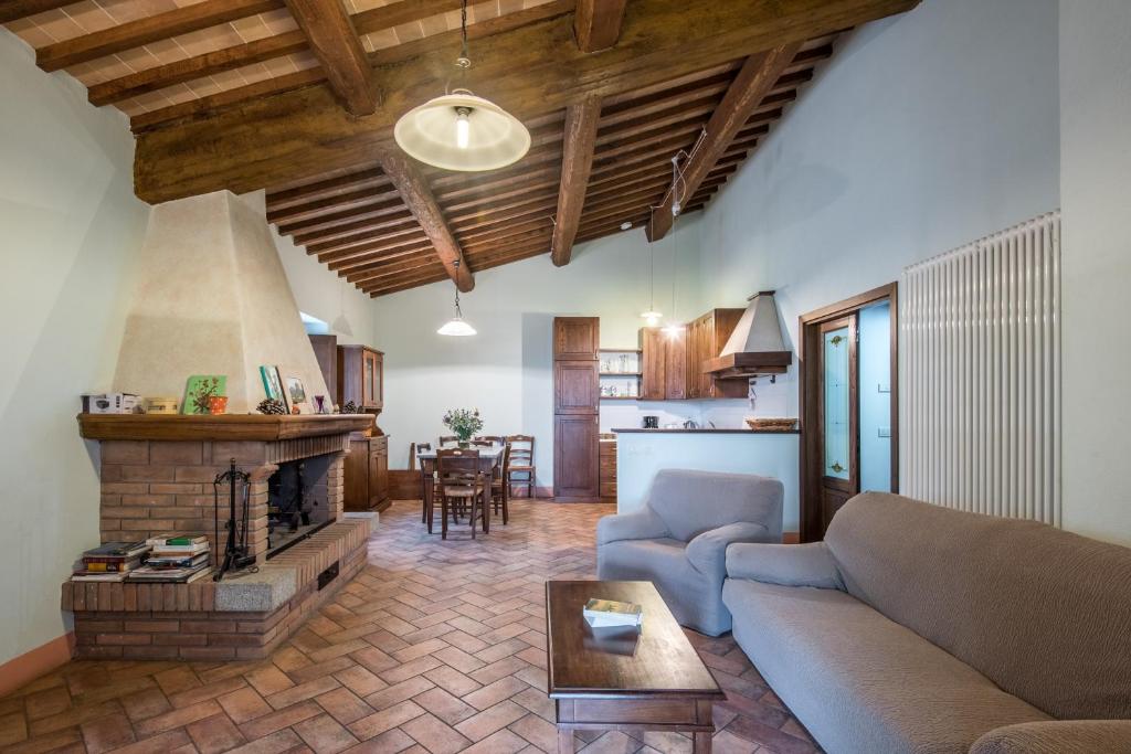 un salon avec un canapé et une cheminée dans l'établissement Villa Agriturismo Il Pratone, à Castiglione dʼOrcia