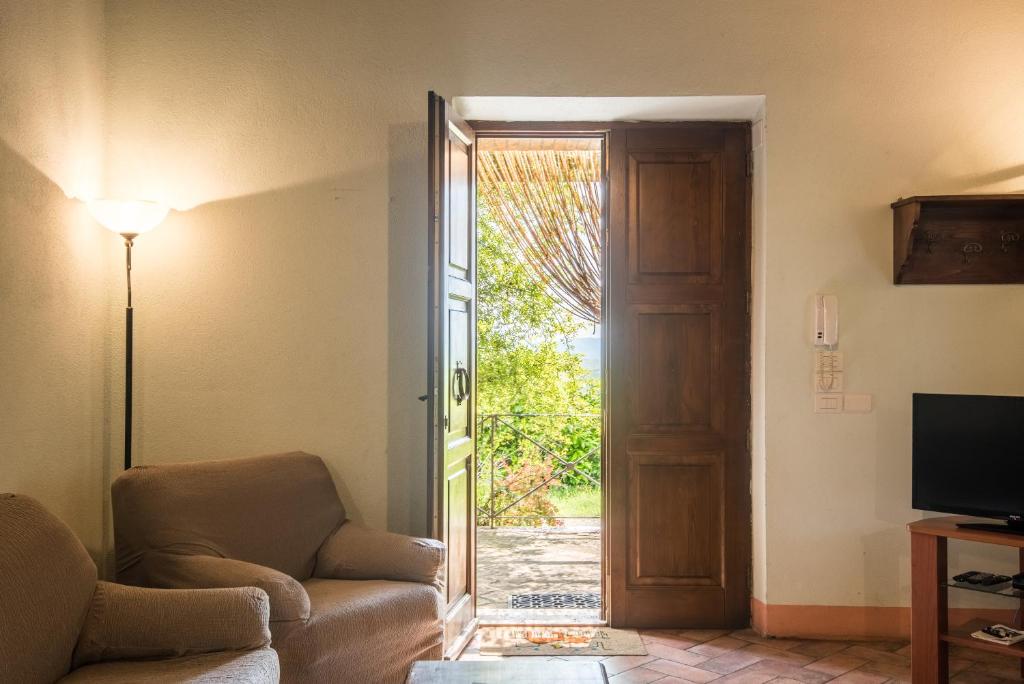 un salon avec un canapé et une porte coulissante en verre dans l'établissement Villa Agriturismo Il Pratone, à Castiglione dʼOrcia