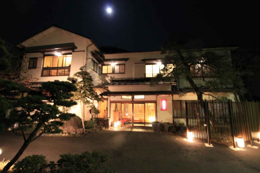 une maison la nuit avec la lune dans le ciel dans l'établissement Yusakaso, à Hakone