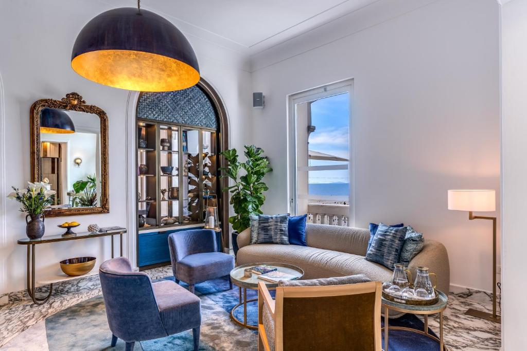 - un salon avec un canapé, des chaises et un miroir dans l'établissement Hotel Mediterraneo, à Sant'Agnello