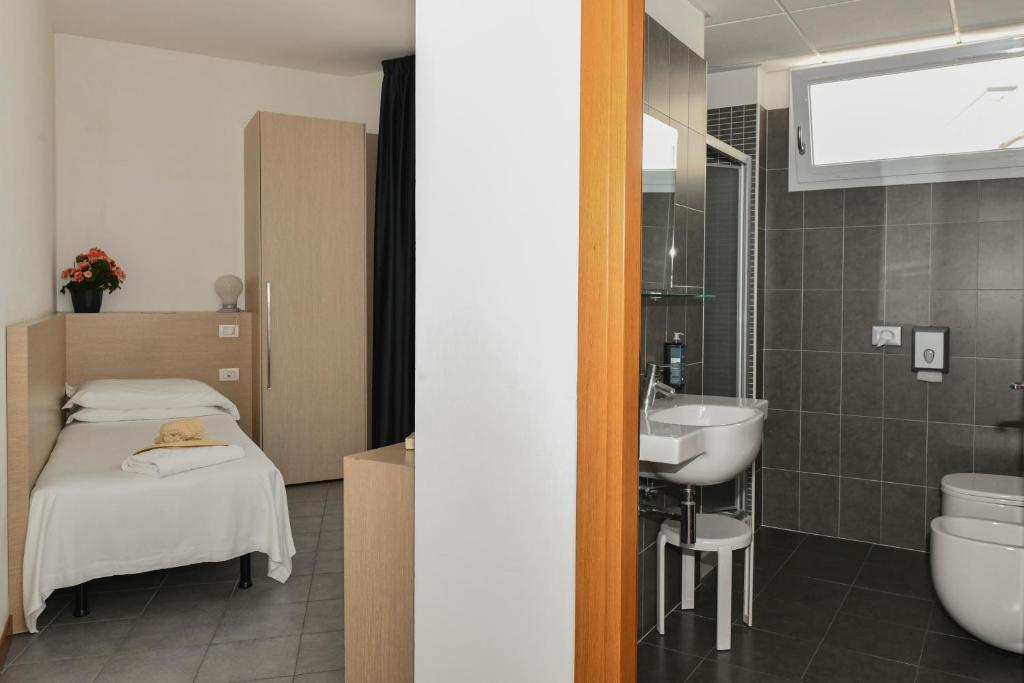 une salle de bain avec un lit et un lavabo dans une chambre dans l'établissement Hotel Eden, à Lido di Jesolo 126 autres photos