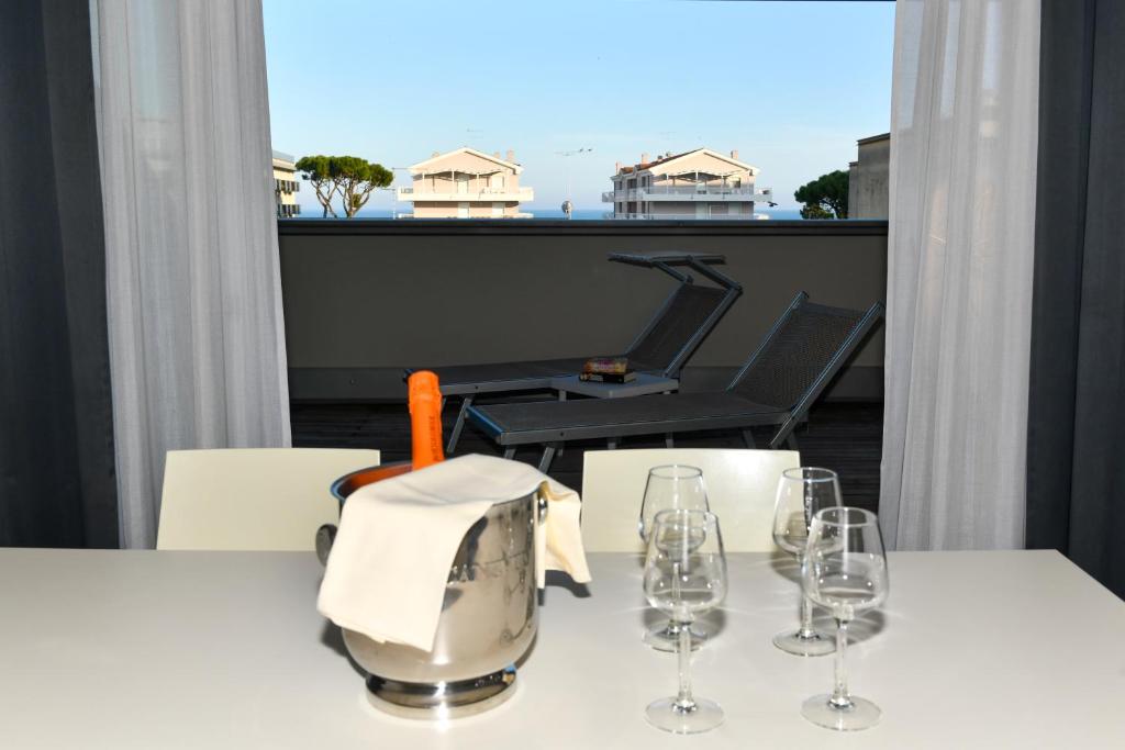 une table blanche avec des verres à vin sur un balcon dans l'établissement Hotel Eden, à Lido di Jesolo