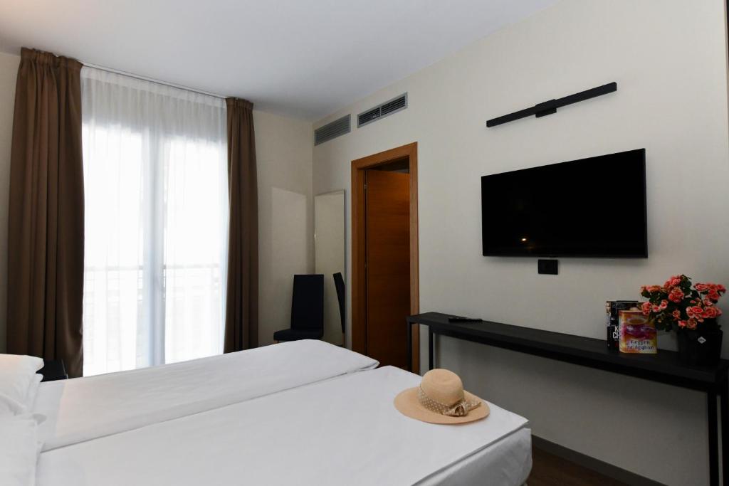 une chambre d'hôtel avec un lit avec un chapeau dessus dans l'établissement Hotel Eden, à Lido di Jesolo
