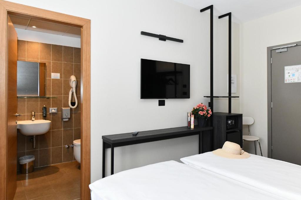 La salle de bains est pourvue d'un lit et d'une télévision murale. dans l'établissement Hotel Eden, à Lido di Jesolo