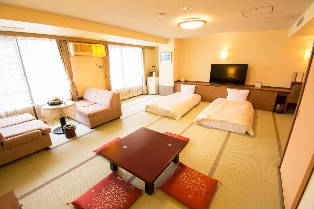 un grand salon avec un canapé et une table dans l'établissement こんぴら温泉 貸切湯の宿 ことね, à Kotohira